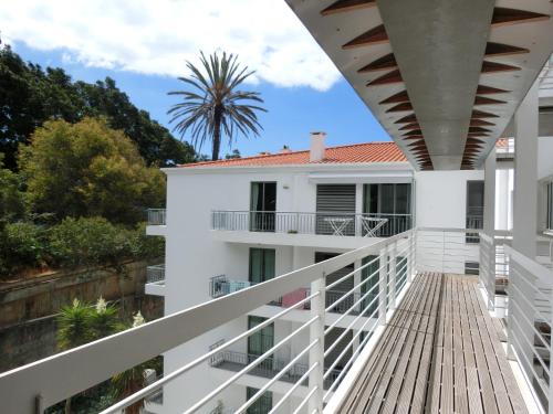 un balcón de una casa con una palmera en el fondo en Marias sea cottage en Funchal