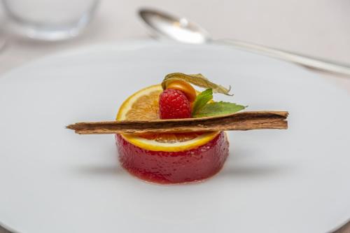 a dessert on a white plate with a strawberry and fruit at Hotel Della Torre in Stresa