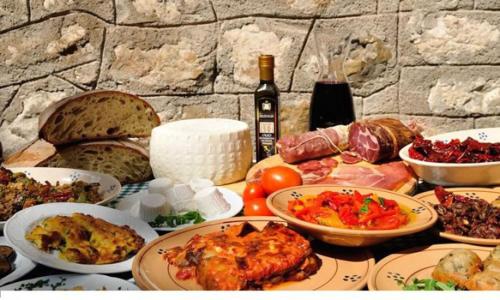 a table with plates of food and a bottle of wine at Casa Ferrara in Francavilla in Sinni