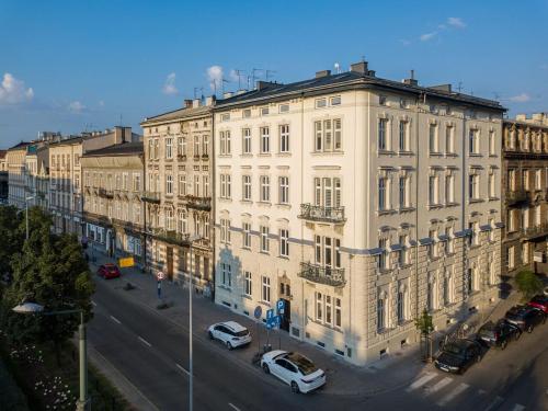 a large white building with cars parked in front of it at DIETLA 99 APARTMENTS - IDEAL LOCATION - in the heart of Krakow in Kraków
