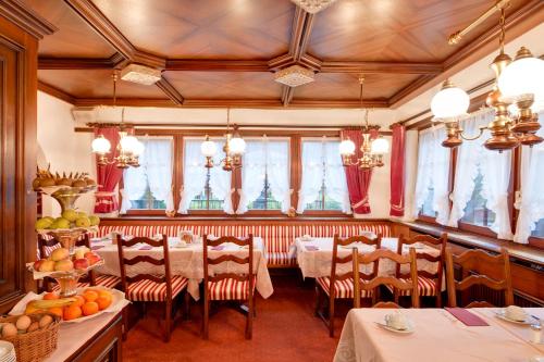 una sala da pranzo con tavoli, sedie e frutta in esposizione di Hotel Astoria a Zermatt