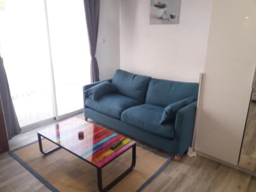 a living room with a blue couch and a glass table at villa alex in Toulouse