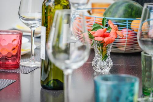 a table with wine glasses and a vase with flowers in it at Guesthouse Klara in Duba Stonska