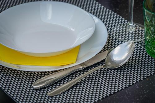 a table with a white plate and two silver spoons at Guesthouse Klara in Duba Stonska
