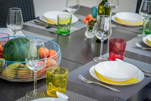 a table with plates and glasses and a bowl of fruit at Guesthouse Klara in Duba Stonska
