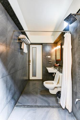 a bathroom with a toilet and a sink at Regenta Resort Soma Vine Village Nashik in Nashik