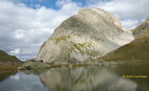 a mountain with a house in the middle of a lake at Gästehaus Lanzinger in Liesing