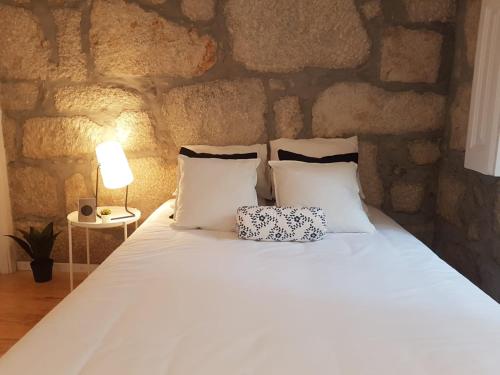 sypialnia z dużym łóżkiem i kamienną ścianą w obiekcie Oporto Foz House close to the beach w Porto