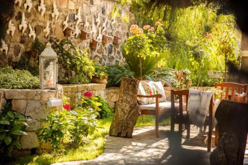 a garden with a table and chairs and plants at Cunda Esen Hotel in Ayvalık