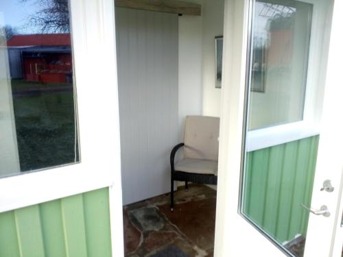 a door to a room with a chair and a window at Kvarngården Natur Resort in Byxelkrok