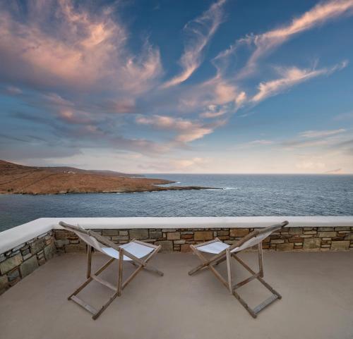 two chairs sitting on a balcony overlooking the ocean at Astrini in Kithnos