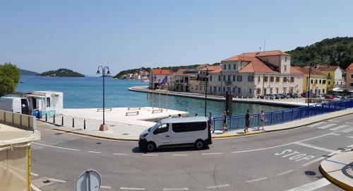 a white van parked on a street near the water at Apartman Kristina in Tisno