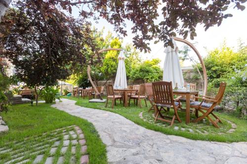 a group of tables and chairs under an umbrella at Cunda Esen Hotel in Ayvalık