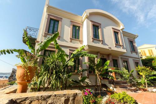 a white house with plants in front of it at Cunda Esen Hotel in Ayvalık