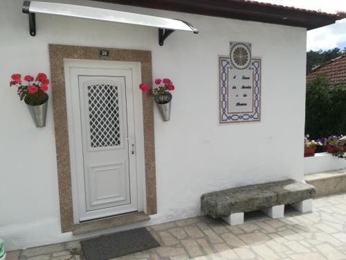 a white house with a white door and flowers at A Tasca in Vila Real