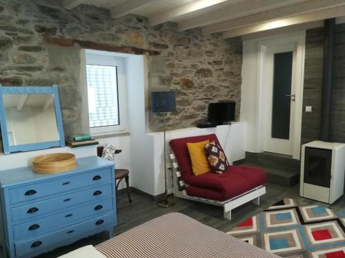 a living room with a red chair and a mirror at A Tasca in Vila Real