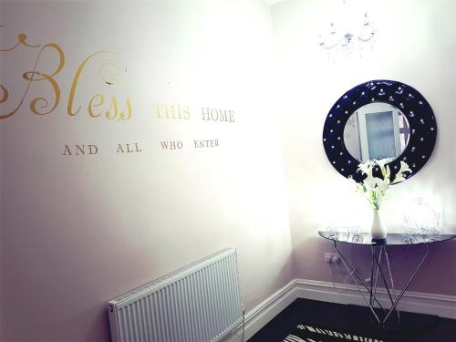 a room with a mirror and a table with a vase at Gabriel Guesthouse in Rhyl