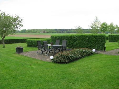 a garden with a table and chairs in the grass at Hof Van Lenthe in Dalfsen