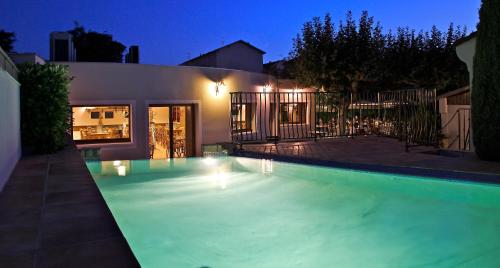 ein Schwimmbad vor einem Haus in der Nacht in der Unterkunft Logis Hotel Le Nouvel in Portes-lès-Valence