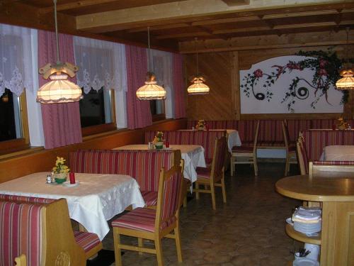 a restaurant with two tables and chairs and lights at Köflerhof Appartements in Sankt Leonhard im Pitztal