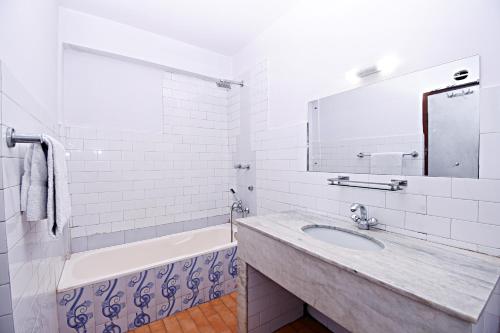 a bathroom with a sink and a tub and a mirror at Hotel Pleasure Home in Kathmandu