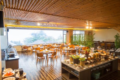 ein Restaurant mit Holzböden, Tischen und Stühlen in der Unterkunft Coral Bay Resort in Phu Quoc