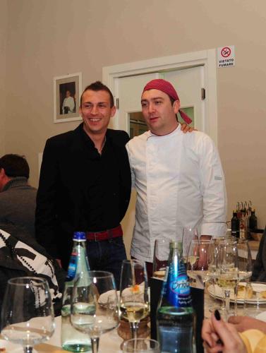 two men standing next to a table with wine glasses at GG8 Hotel & Suite SPA in Gualdo Tadino