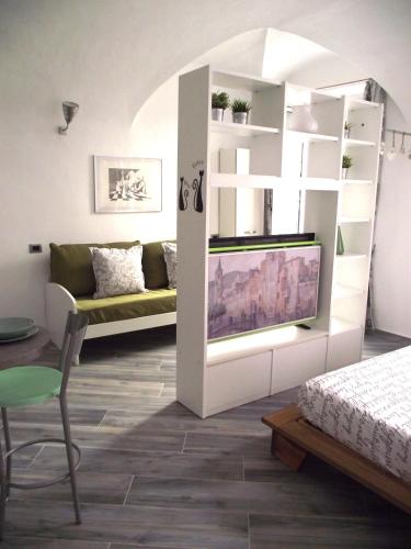 a living room with a couch and a tv in a room at Casa Bartelli in Finale Ligure