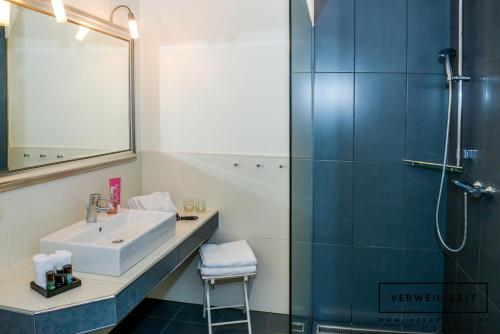 a bathroom with a sink and a shower at Verweilzeit Appartementhaus in Ramsau am Dachstein
