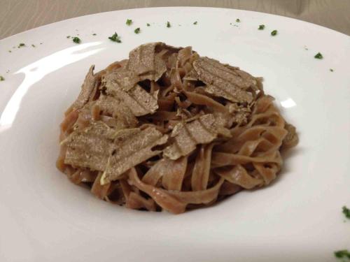 a plate of pasta on a white plate at GG8 Hotel & Suite SPA in Gualdo Tadino