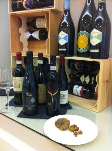 a bunch of bottles of wine and a plate of cookies at GG8 Hotel & Suite SPA in Gualdo Tadino