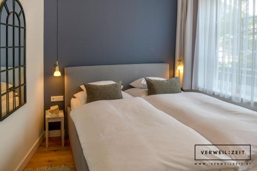 a bedroom with two beds and a window at Verweilzeit Appartementhaus in Ramsau am Dachstein