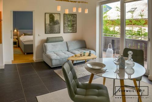 a living room with a table and a couch at Verweilzeit Appartementhaus in Ramsau am Dachstein