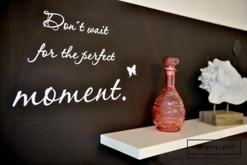 a message on a wall with a vase on a shelf at Verweilzeit Appartementhaus in Ramsau am Dachstein