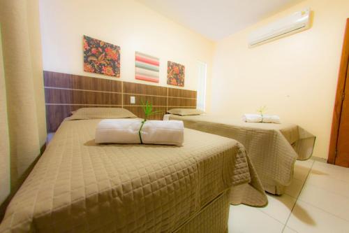 a room with two beds in a room at Residencial Portinari LTDA in Porto Seguro