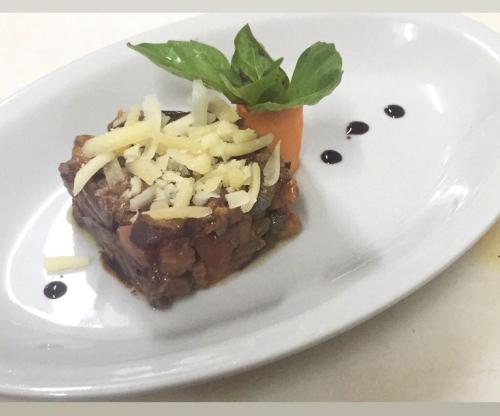 a white plate with a piece of food on it at Hotel Rodà in Panarea