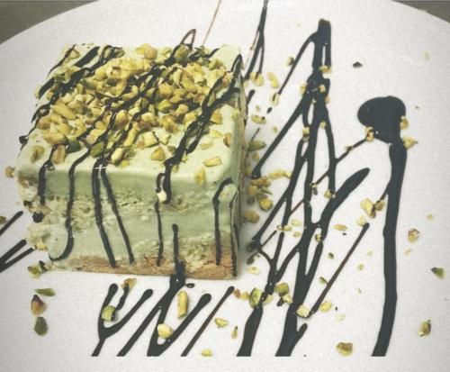 a cake on a white plate with black frosting and nuts at Hotel Rodà in Panarea