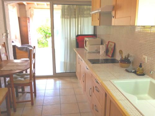 a kitchen with a counter with a sink and a table at Leucate,dans la verdure,studio caverne en pierre dans propriété sécurisée in Leucate