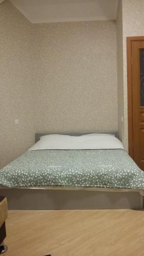 a bedroom with a bed with a green comforter at Joniskera in Tbilisi City