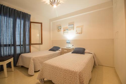 サロウにあるMalvinas IBERPLAYAのベッド2台と窓が備わる客室です。