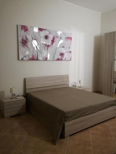 Un dormitorio con una cama y un cuadro en la pared. en Residence Salento, en Palmariggi
