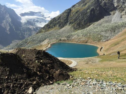 a man standing on the side of a mountain with a lake at Appartements Olympia in Mayrhofen