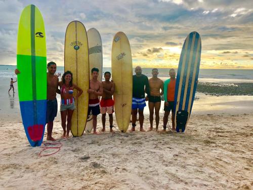 a group of people standing on the beach with their surfboards at Hostel Jericoacoara in Jericoacoara
