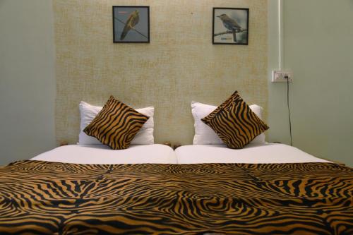 a bed with two pillows on top of it at Baaz Jungle Resort in Khawāsa