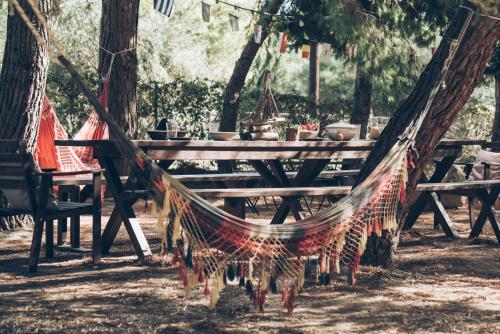 a wooden picnic table with hammocks in a park at Alegria Villas Complex in Vasilikos