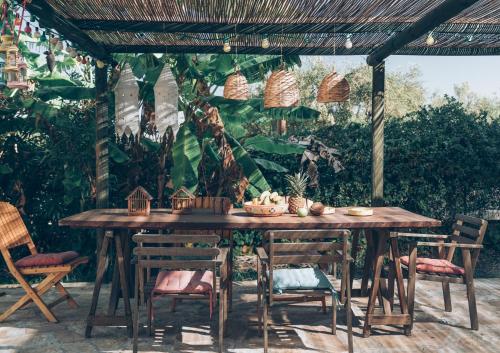 a wooden table and chairs under a pergola at Alegria Villas Complex in Vasilikos