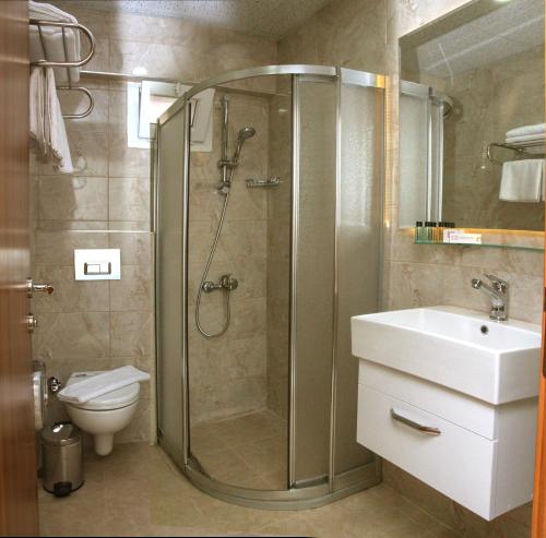 een badkamer met een douche, een wastafel en een toilet bij Green Garden Hotel in Istanbul