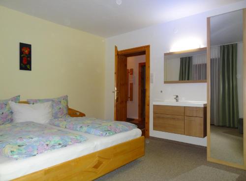 Un dormitorio con una cama, un lavabo y un espejo. en Ferienwohnung Frenner, en Sankt Martin bei Lofer