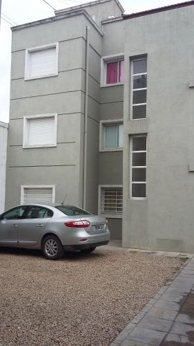 un coche plateado estacionado frente a un edificio en Departamento de Celina en Olavarría