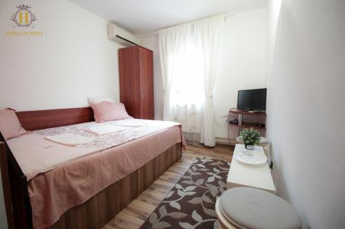 Dormitorio pequeño con cama y aseo en Hanul lui Țintă, en Buzău